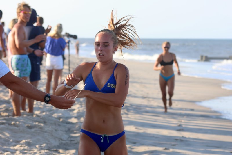 Maura Lenhart of Delaware State Parks Beach Patrol crosses the finish line first in the women’s one-mile run.